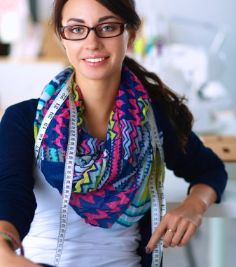 Güzel moda tasarımcısı stüdyoda duruyor.