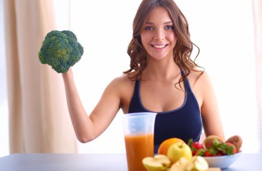 Genç ve güzel bir kadın mutfakta yemek pişiriyor.