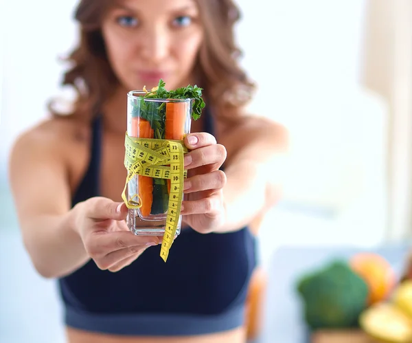 Žena držící sklenici plnou čerstvého ovocného salátu s páskou kolem sklenice — Stock fotografie