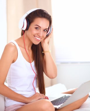 Genç güzel kadın yatakta müzik