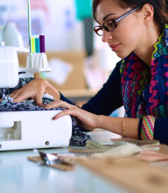 Çalışırken dikiş diken genç bir kadın.