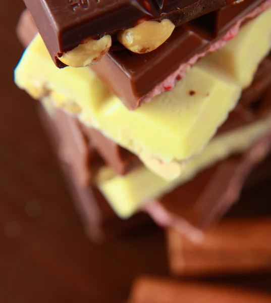 Stapel von Schokoladenstücken auf einem Holzhintergrund — Stockfoto