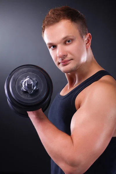 Schöner muskulöser Mann, der mit Hanteln trainiert — Stockfoto