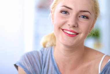 Genç ve güzel bir kadın odasında kanepede oturuyor.