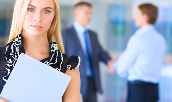 Business woman standing in foreground  in office — Stock Photo, Image