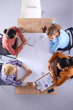 İş adamları iş toplantısında, ofiste oturup tartışıyorlar.