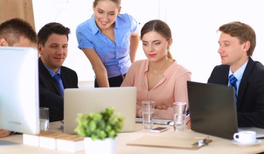 İş adamları iş toplantısında, ofiste oturup tartışıyorlar.