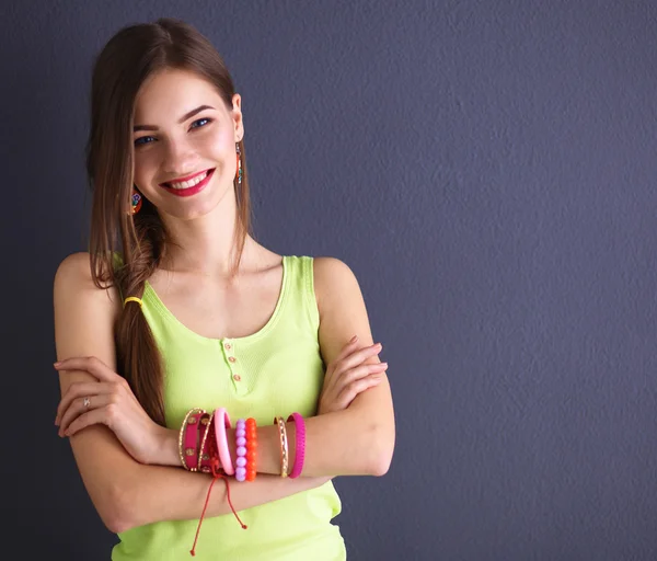 Young woman standing near dark wall — Stock Photo, Image