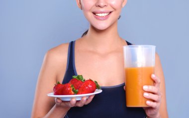 Vejetaryen sebze salatasıyla gülümseyen genç bir kadının portresi.