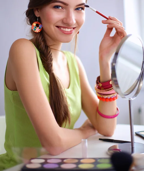 若い美しい女性化粧鏡、机に座っての近く — ストック写真