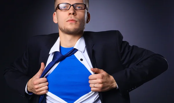 Young businessman acting like a super hero and tearing his shirt, isolated on gray background — Stock Photo, Image