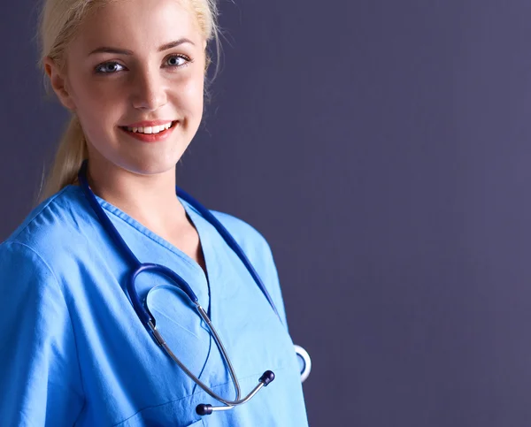 Mujer doctora joven con estetoscopio aislado sobre fondo gris —  Fotos de Stock