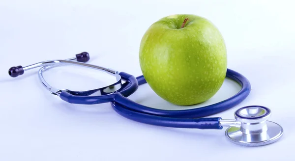Медицинский стетоскоп и яблоко изолированы на белом фоне Стоковое Изображение