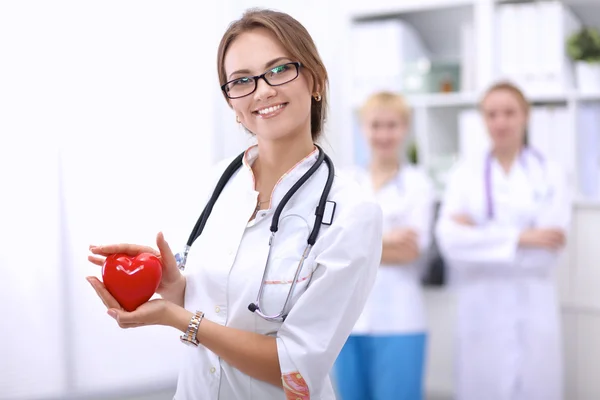 Médico com estetoscópio segurando coração, isolado em fundo branco — Fotografia de Stock