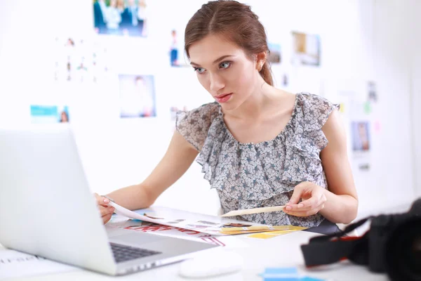 Aantrekkelijke zakenvrouw zit op het bureau in het kantoor — Stockfoto