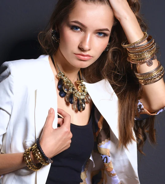 Portrait of young woman with beads, standing on black background — Stock Photo, Image