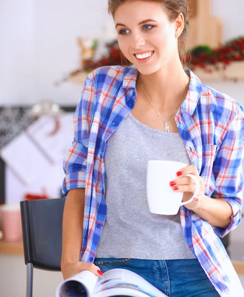 Mujer leyendo mgazine En la cocina en casa —  Fotos de Stock