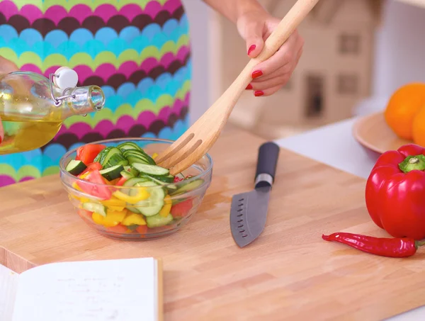 Lächelnde junge Frau mixt frischen Salat — Stockfoto