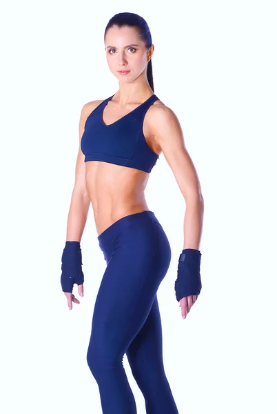 Muskuløs ung kvinde poserer i sportstøj på hvid baggrund - Stock-foto