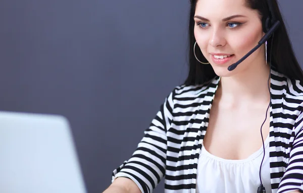 Belle femme d'affaires travaillant à son bureau avec casque et ordinateur portable — Photo