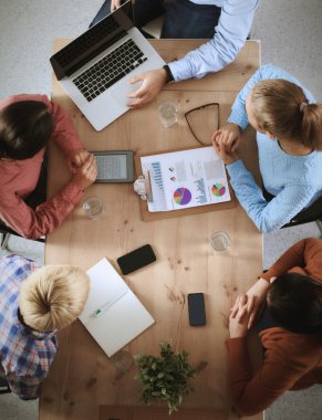 İş adamları iş toplantısında, ofiste oturup tartışıyorlar.