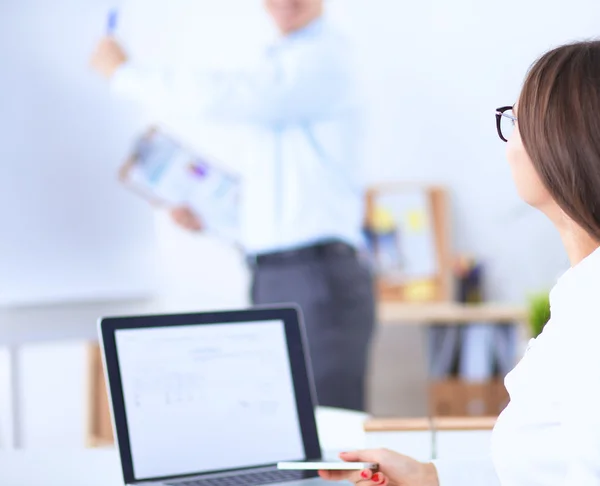 Aantrekkelijke zakenvrouw zit op het bureau in het kantoor — Stockfoto