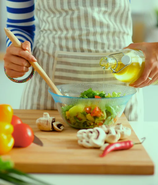 Mujer joven sonriente mezclando ensalada fresca —  Fotos de Stock