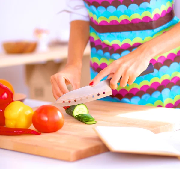 Mujer joven cortando verduras en la cocina — Foto de Stock