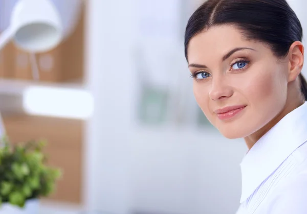 Attractive businesswoman sitting  on desk in the office — Stock Photo, Image