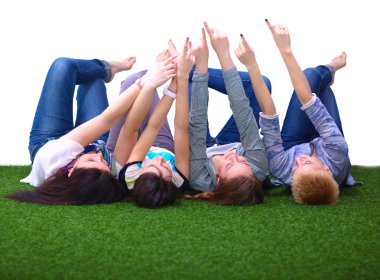 Dört genç kadın yeşil çim üzerinde yalan