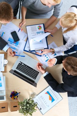 İş adamları iş toplantısında, ofiste oturup tartışıyorlar.