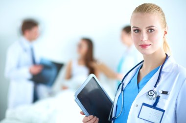 Kadın doktor hastanede dosyayla bekliyor.