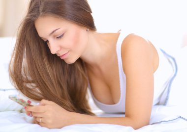 Ateş güzel bir genç kadının yatağında yatan bir kısa mesaj okuma