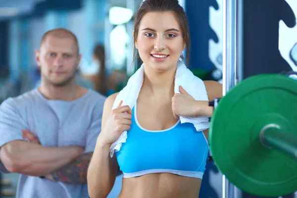 Schöne Frau im Fitnessstudio beim Training mit ihrem Trainer — Stockfoto