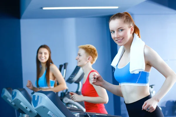 Gruppe von Menschen in der Turnhalle, die auf Crosstrainern trainieren — Stockfoto