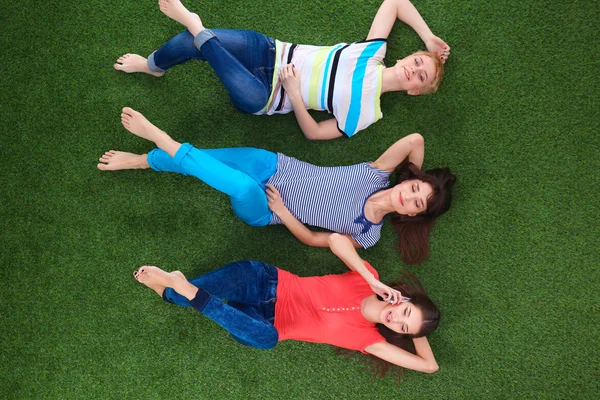 Giovani donne sorridenti sdraiate sull'erba verde — Foto Stock