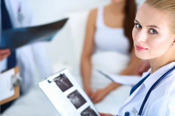 Cirurgião e médico analisando raio-X juntos em consultório médico — Fotografia de Stock