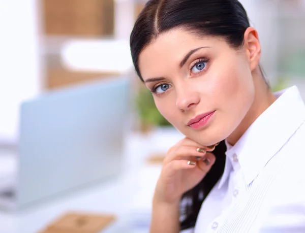 Attractive businesswoman sitting  on desk in the office — Stock Photo, Image