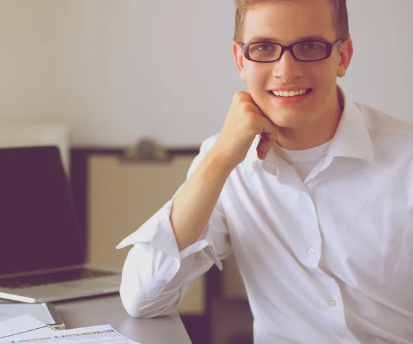 Молодой бизнесмен, работающий в офисе, стоящий у стола — стоковое фото