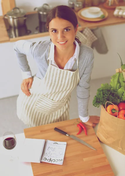 Mujer haciendo comida saludable de pie sonriendo en la cocina — Foto de Stock