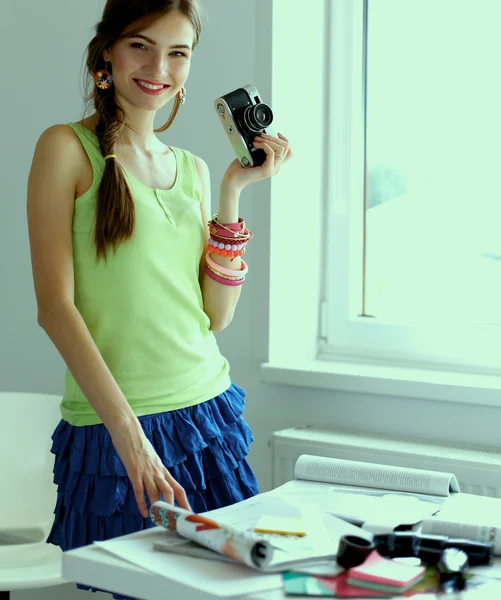窓の近くに立ってカメラを持つ美しい若い女性 — ストック写真