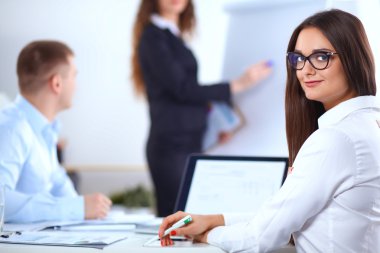 İş adamları iş toplantısında, ofiste oturup tartışıyorlar.