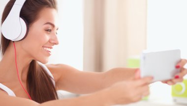 Genç güzel kadın yatakta müzik