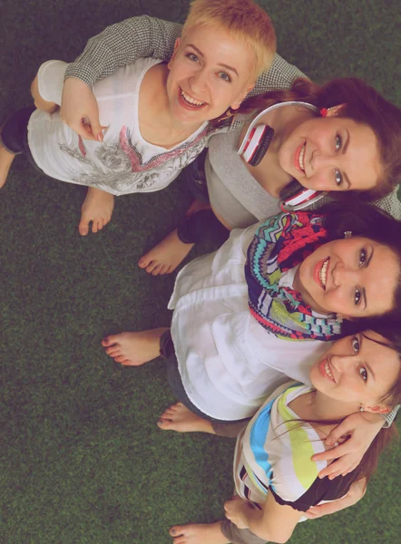 Quatre jeunes femmes debout sur l'herbe verte — Photo