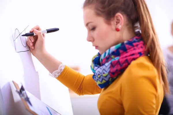 Young woman standing near board with folder — Stock Photo, Image