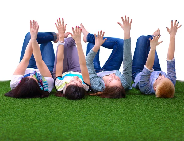 Four young women lying on green grass — Stock Photo, Image