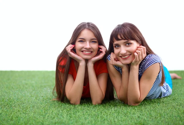 Deux jeunes femmes allongées sur l'herbe verte — Photo