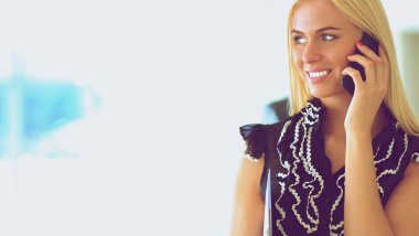 Ofiste cep telefonu kullanan güzel bir iş kadını.