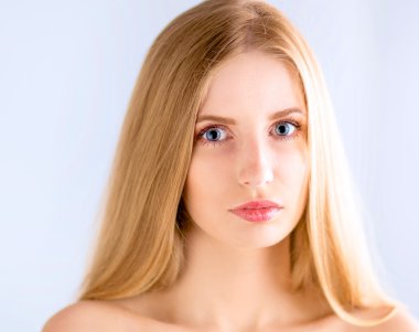 Gri arka planda izole edilmiş güzel bir kadının portresi.