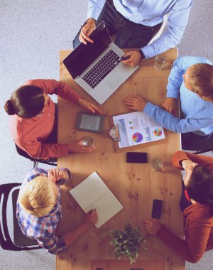 İş adamları iş toplantısında, ofiste oturup tartışıyorlar.